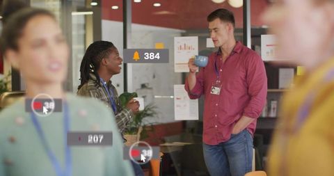 Coworkers chatting over coffee in lounge with notification icons and id badges