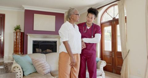 Caregiver Assisting Senior Woman in Living Room for Health Checkup
