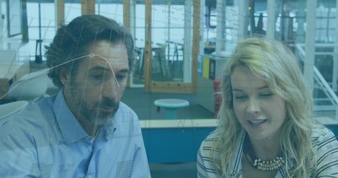 Caucasian Businessman and Businesswoman Analyzing Data on Screen