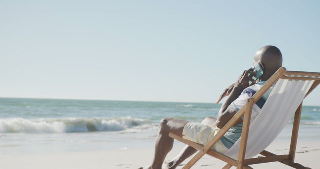 Man Relaxing on Beach Chair Making Phone Call by Ocean - Download Free Stock Images Pikwizard.com