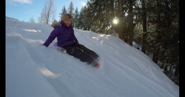 Child in Joyful Winter Adventure Sliding Down Snowy Hill - Download Free Stock Images Pikwizard.com