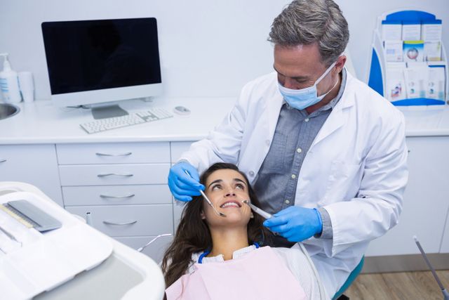 Doctor examining patient at dental clinic