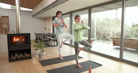 Couple Practicing Yoga Indoors for Wellness and Serenity