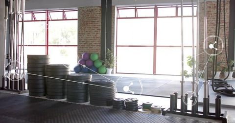 Industrial crossfit gym displaying stacked bumper plates, barbells and medicine balls