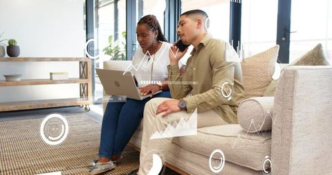 Young professionals collaborating on laptop with hud analytics overlays in modern lounge