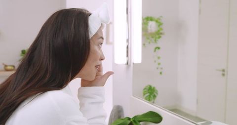 Asian Woman Practicing Skincare Routine Bathroom Reflection