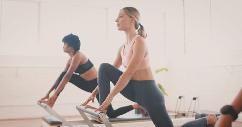Women Exercising Yoga on Reformers in Studio Environment