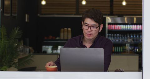 Businessman Using Laptop While Relaxing in Cafe
