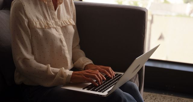 Woman Typing on Laptop Sitting on Couch by Window - Download Free Stock Images Pikwizard.com