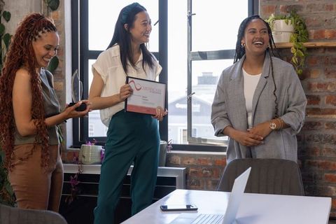 Diverse Female Professionals Celebrating Success at Meeting