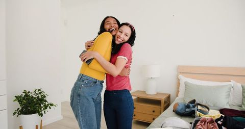 Mother and Daughter Joyfully Hugging in Bedroom Creating Happiness