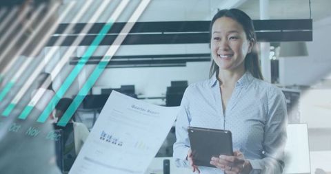Smiling Asian businesswoman presenting quarterly report holding tablet in modern office