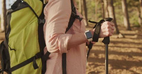 Senior Woman Hiking with Backpack and Smartwatch in Sunny Forest - Download Free Stock Images Pikwizard.com