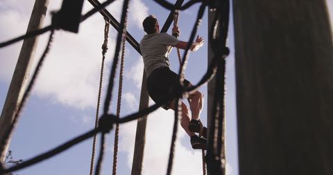 Man Climbing Rope on Outdoor Obstacle Course