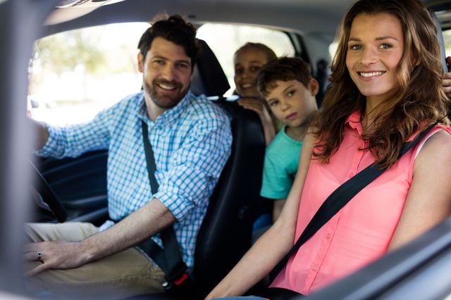 Portrait of happy family sitting in car