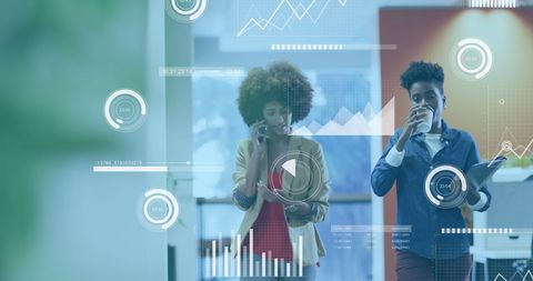 Businesswomen Analyzing Digital Data in Modern Office Environment