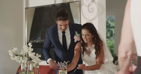 Bride and Groom Cutting Wedding Cake with Joy