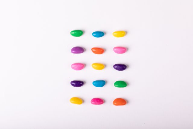This image of colorful candies arranged in a grid on a white background is perfect for use in advertising campaigns for confectionery products, social media posts about sweets, or as a vibrant background for websites and blogs. The bright colors and minimalistic design make it eye-catching and versatile for various creative projects.