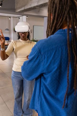 African american coworkers testing vr headset while woman gesturing in open-plan office