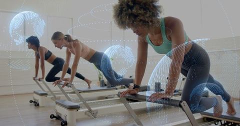 Women Exercising on Reformers with Digital Orbit Overlay in Gym