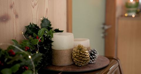 Festive Christmas Decor with Candles and Holly on Rustic Table