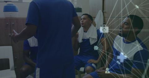 Soccer players discussing tactics in locker room with digital strategy overlay