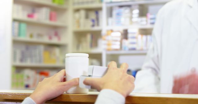 Pharmacist giving pill bottle to customer in pharmacy 