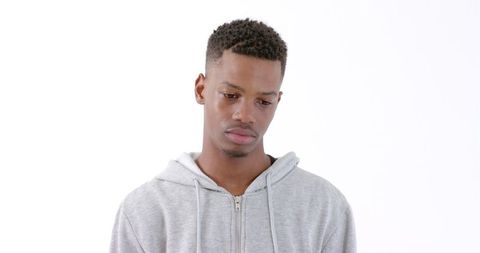 Young Man Pondering in Gray Hoodie with Neutral Expression - Download Free Stock Images Pikwizard.com