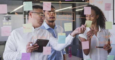 Diverse Team Brainstorming Ideas on Glass Board in Office