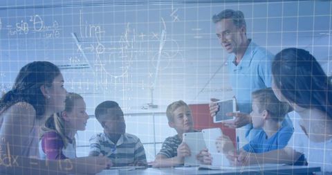 Male Teacher Explaining with Tablets to Diverse School Children in Classroom