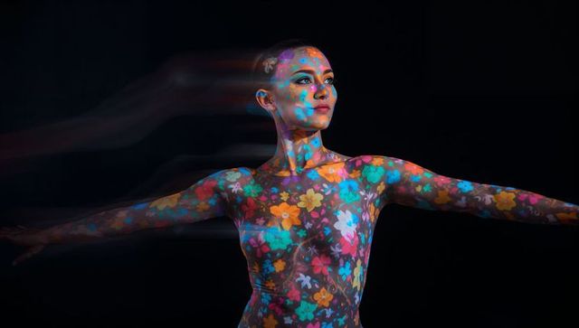 Floral projection on woman in motion — vibrant body mapping, colorful artistic portrait