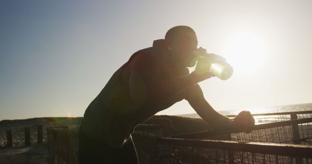 Athlete Drinking Water While Resting at Sunset on Beach - Download Free Stock Images Pikwizard.com