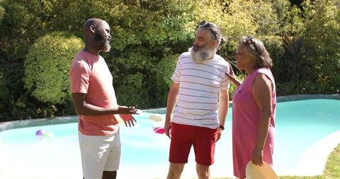 Senior Friends Gathering By Pool for Outdoor Relaxation