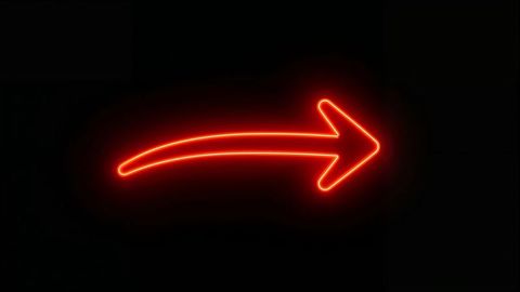 Glowing red neon curved arrow sign on dark wall