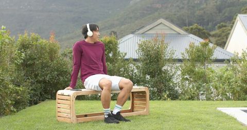 Man Relaxing Outdoors with Headphones in Peaceful Backyard Setting