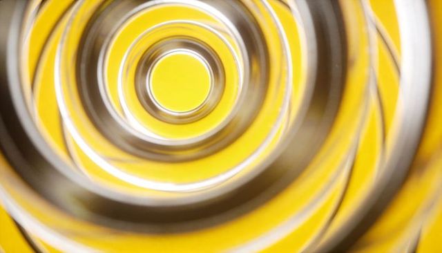 Spiraling metallic rings converging on bright yellow core abstract radial tunnel symmetry