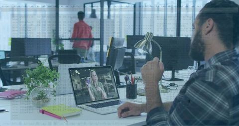 Remote team collaborating over video call in modern open office with tech code overlay
