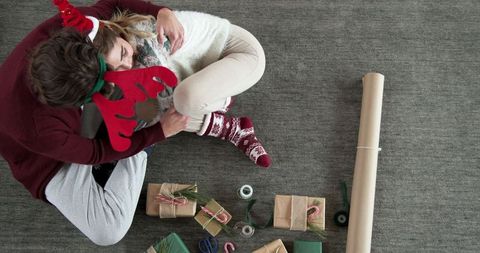 Top view women wrapping christmas gifts with seasonal decorations