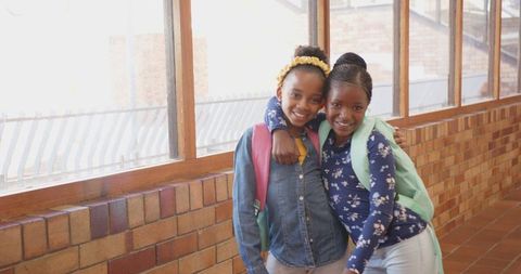 Joyful School Friends with Backpacks Embracing in Corridor