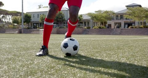 Athlete Dribbling Soccer Ball on Turf Field in Sunshine