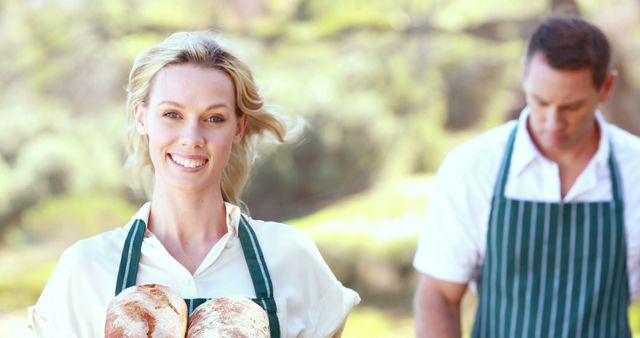 Cheerful woman holding fresh baked bread in outdoor setting - Download Free Stock Images Pikwizard.com