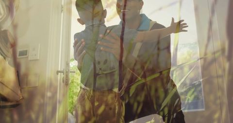 Joyful father and son embrace with nature overlay