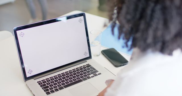 Person using laptop with blank white screen on desk - Download Free Stock Images Pikwizard.com