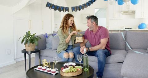 Couple Celebrating Birthday with Small Gifts in Cozy Living Room