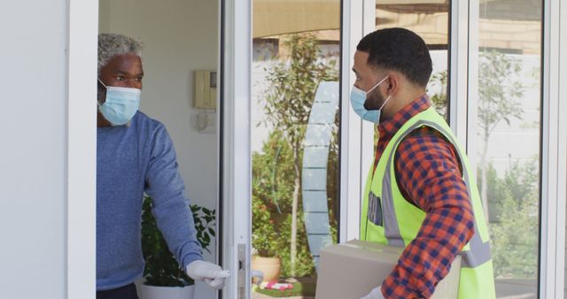 Delivery Worker Handing Package to Man at Home Wearing Masks - Download Free Stock Images Pikwizard.com