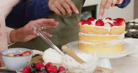 Decorating Layered Cake with Strawberries and Cream