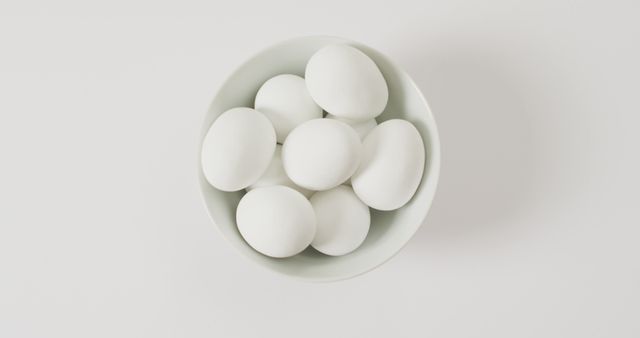 Close up of bowl of white eggs with copy space on white surface. organic food and nutrition concept