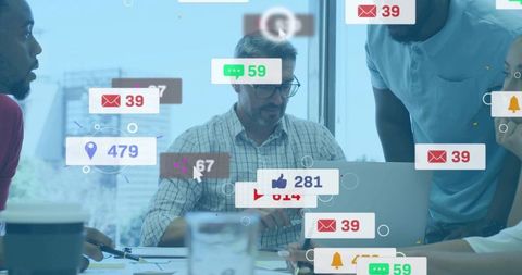 Colleagues Collaborating Around Laptop with Social Media Notifications Overlaying Office