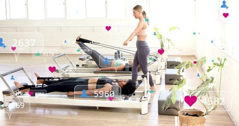 Instructor guiding participants performing reformer leg extensions in bright pilates studio
