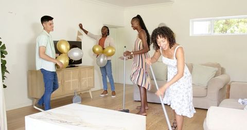 Diverse Friends Decorating Home with Balloons for Celebration